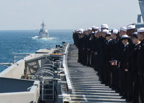 登舷礼を行う空母ロナルド・レーガン乗組員。奥は先導の護衛艦てるづき（photo:U.S.NAVY）