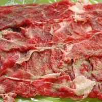 1：薄切り肉をラップに広げて塩コショウをする。