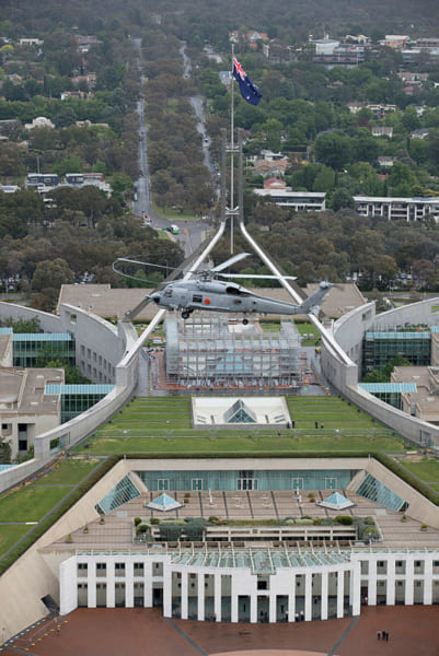 連邦議会議事堂上空を飛ぶS-70B-2（画像：(c) Commonwealth of Australia）
