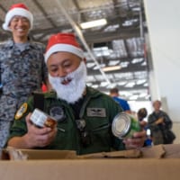 クリスマス・ドロップ作戦で島々へ届けるプレゼントを選ぶ航空自衛隊第401飛行隊の自衛官（Image：USAF）