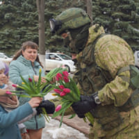 子供たちに花をプレゼントするロシアの契約軍人（Image：ロシア国防省）