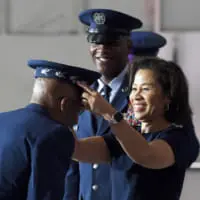 敗軍者のシャレーンさんから帽子をかぶせてもらうブラウン大将（Image：USAF）