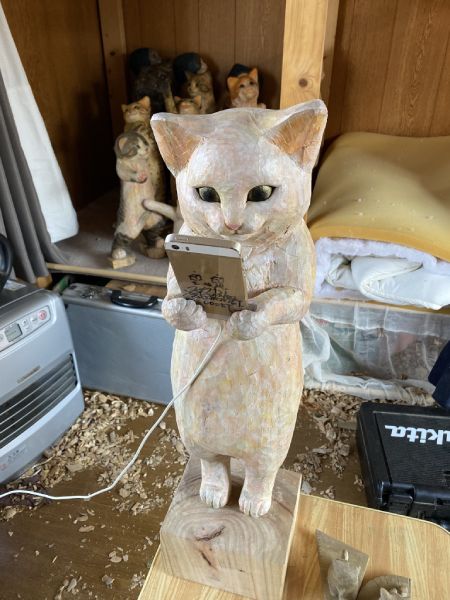 「猫」の正体は、実はスマートフォン置きの木彫りアート。
