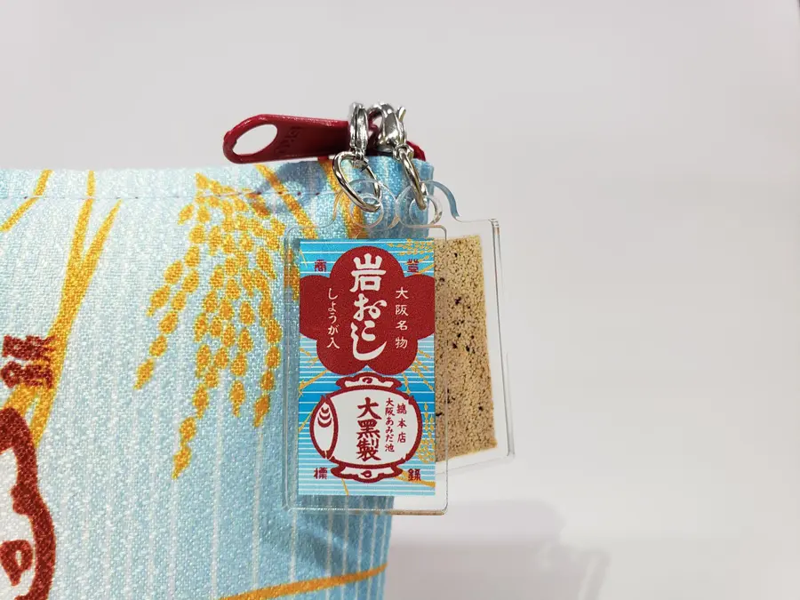 フラットポーチはミニチュア岩おこしストラップ付き
