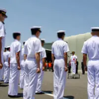 拳を握って「気をつけ」の姿勢を取る海上自衛官