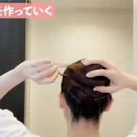 ポニーテールをねじりながら髪の毛をゴムにそってまきつけ、シニヨンの形にします