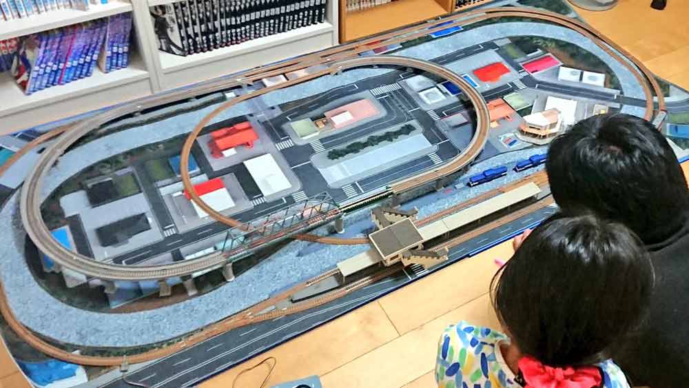 鉄道模型のレイアウトを覗き込むSERENAさんと当時6歳の娘さん（SERENAさん提供）