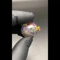 辺り一面に蝶や花のデザインが施されたペンダント。