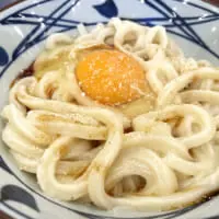 丸亀製麺の釜玉うどんと、だし醤油をかけた様子