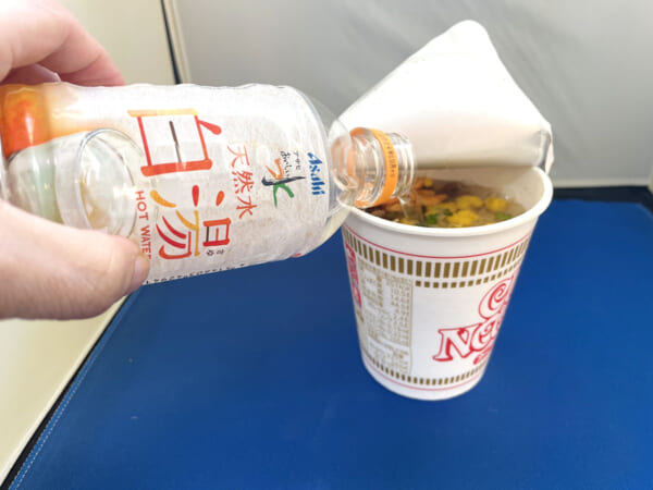 白湯をカップラーメンに注いでいるところ