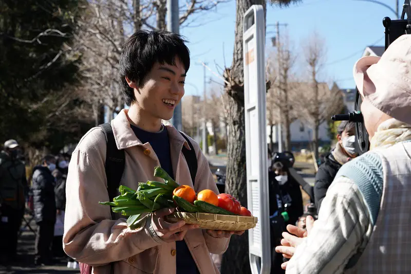たくさんの野菜を持ったままバスを追いかけて転ぶシーンの撮影