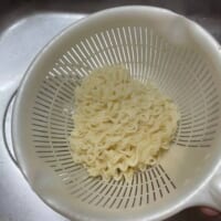 茹でた面を湯切りして皿に移す