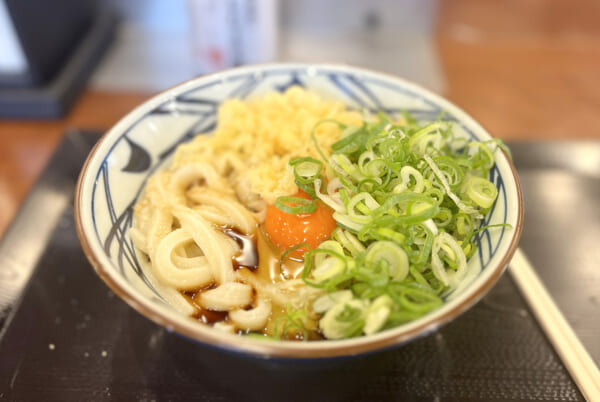 丸亀製麺「釜玉うどん」に天つゆをかけて、ネギなどを入れた