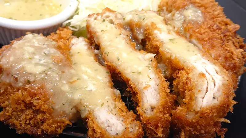 「ロースミルフィーユかつ」にガーリックバターソースをたっぷりかける