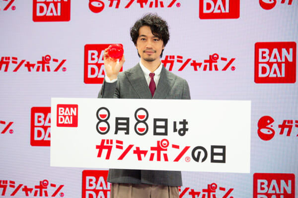 ガシャポン史上最大”90mmカプセル”を手に、8月8日「ガシャポンの日」をPRする斎藤工さん
