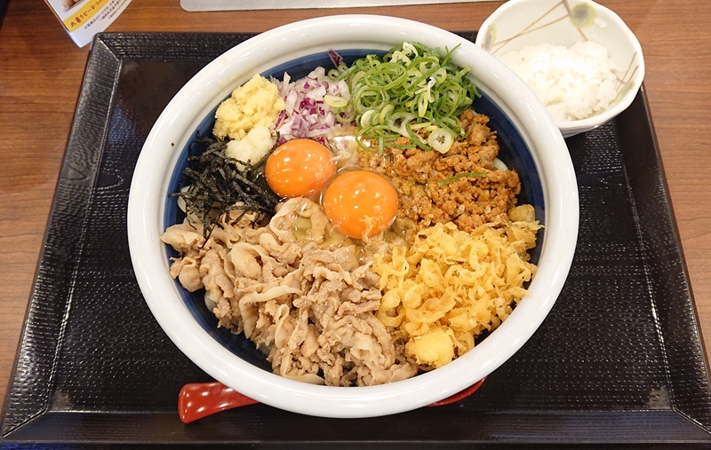 「旨辛 肉盛りまぜ玉うどん」の「得」（税込1110円）