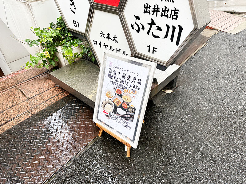 ビルの外に出た「罪無き麻婆豆腐 100％ plants base vegan mapo tofu」という看板が営業中の目印