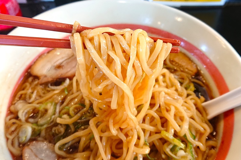 スープがよく絡みついているので少し茶色く見える麺