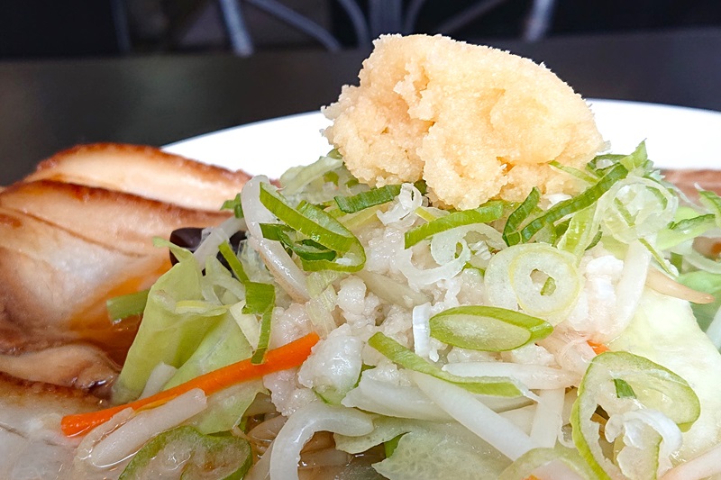 チャーシューの上にトッピングされている野菜や背脂、にんにくなど