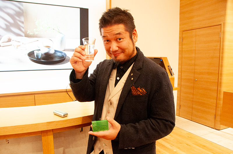 「Sake Marriage」のマリアージュメニューを手にポーズを決める監修担当・岩崎泰三さん