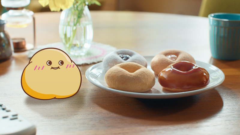 「55年目の新食感だよ～！」と呼びかけるドーナツキャラクター