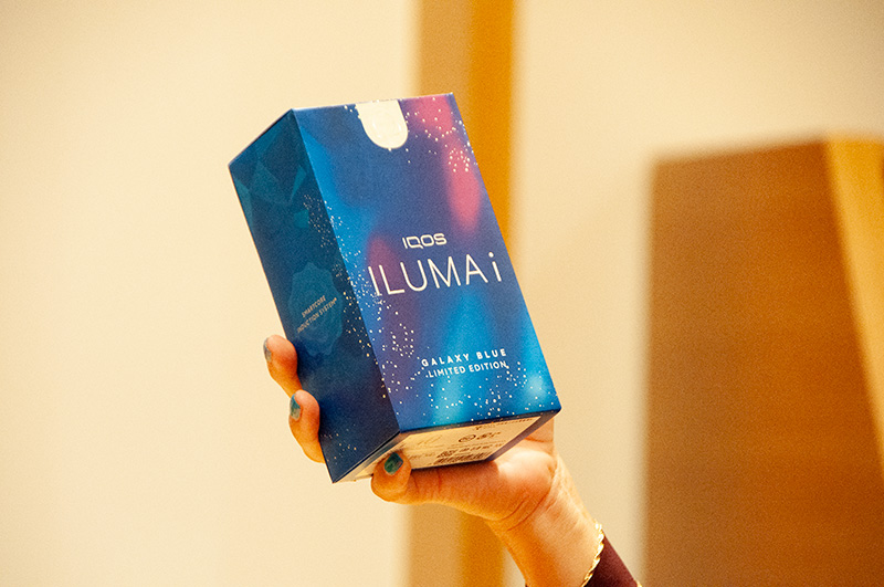深い宇宙の夜空をモチーフに、輝く星たちを銀色の箔で表現した「IQOS ILUMA i ギャラクシーブルー モデル」のパッケージ
