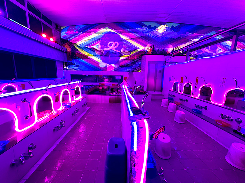 ブラックライトの中に極彩色のネオンが光る浴室