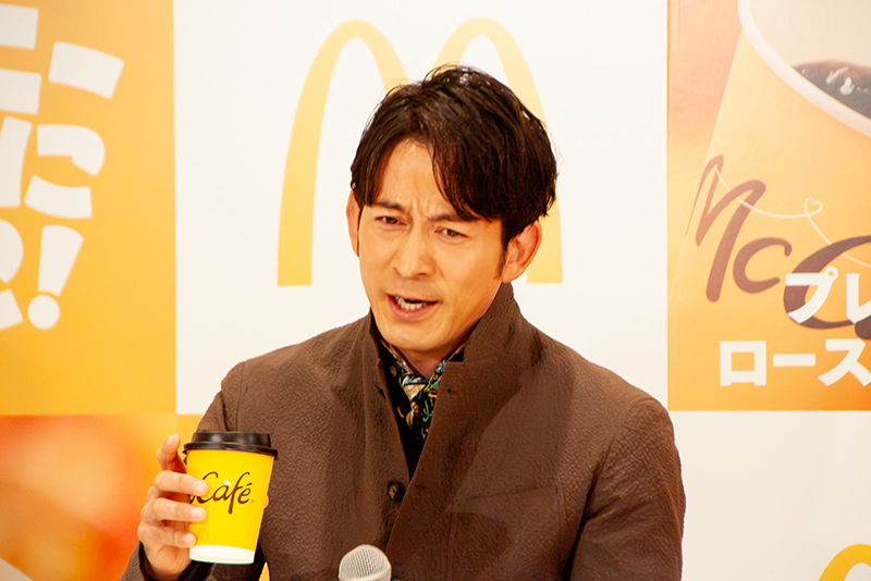 新「プレミアムローストコーヒー」(ホット)を飲み、「コクが一段と深くなっている」と絶賛する岡田准一