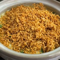 「チキンラーメン」を、そのまま豪快に手で砕いて雑炊の上から振りかける