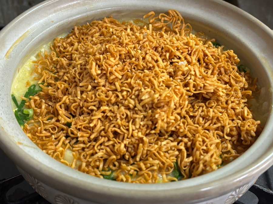 「チキンラーメン」を、そのまま豪快に手で砕いて雑炊の上から振りかける